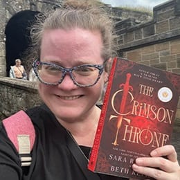 Beth Revis, an adjunct instructor at SNHU holding her book 'The Crimson Throne.'