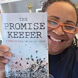 Dr. Lisa Wood, a 2018 MA in English and Creative Writing and 2019 MFA in Creative Writing alum, adjunct instructor and  team lead at SNHU holding her book 'The Promise Keeper.'