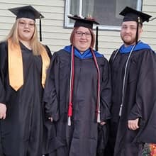 Kayla, Tara and George Conrad celebrate their graduation in their caps and gowns