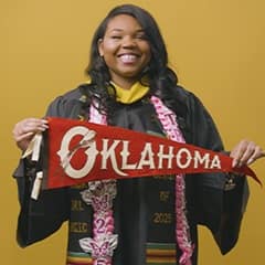 Triniti Adams '25, BS in Public Health grad from SNHU, holding an Oklahoma state pennant.