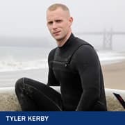 Tyler Kerby, who earned an online bachelor's in general studies from SNHU in 2014, wearing a wet suit and holding a surf board at the beach.