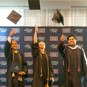 Adrianna Buxrude, Anthony Powell and Juvenal Rivera III throwing their graduation caps in the air