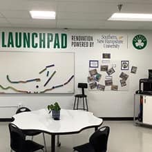 The new STEAM lab at Webster Elementary School with logos and lettering on the wall that say Launchpad Renovation Powered by Southern New Hampshire University and Celtics. 