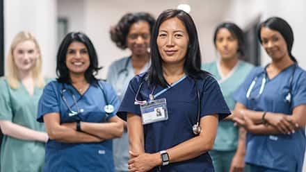 6 nurse leaders wearing medical scrubs and stethoscopes.