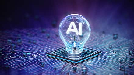 A lightbulb that says "AI" in the center screwed in a purple, blue and black circuit board.