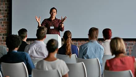 A teacher standing in front of a classroom teaching what can you do with a communications degree 