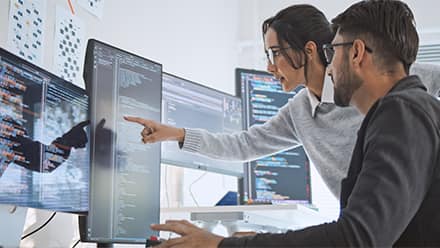 Two computer science professionals using their skills at work.