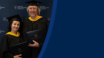 2024 SNHU graduates, David and Irina Roach, who earned their master's in cybersecurity, holding their diplomas, wearing their caps and gowns in front of a blue background.