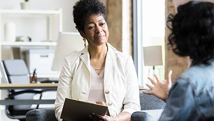 A psychiatrist speaking to a patient in their office.