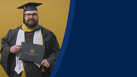 Frank Milisi, an SNHU graduate with a bachelor's in computer information systems, dressed in his graduation cap and gown.