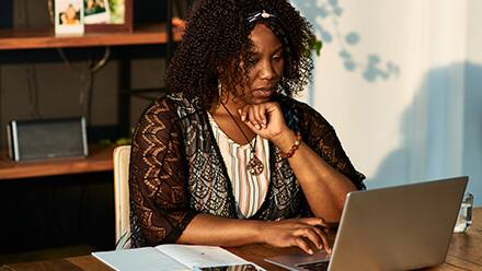 A woman working on her online graduate certificate courses from her laptop.