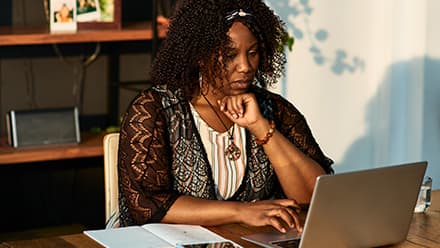 A woman working on her online graduate certificate courses from her laptop.