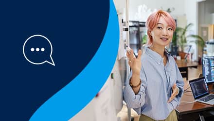 A marketer presenting to a group of people at a whiteboard with a talk bubble to the left on a blue background.
