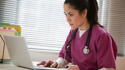 A nurse practitioner working on her laptop