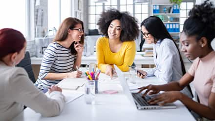 A group of professionals discussing how to become a social media manager.