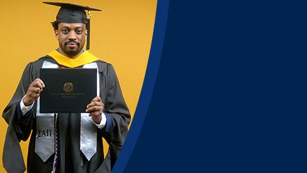 Josiah Lee, a 2025 master's in cybersecurity graduate from SNHU, wearing a cap and gown and holding his diploma.