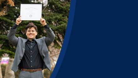 Kevin Bucardo '25MBA, MBA with a concentration in Finance graduate from SNHU, holding his diploma over his head.