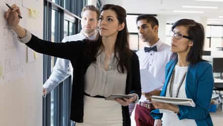 Business professionals discussing the advantages of an online master's in organizational leadership 