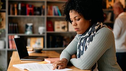 A student studying her textbook as she pursues a master's degree