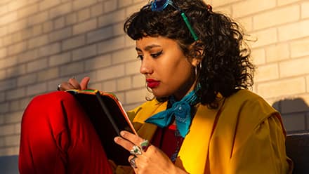 A woman writing down her SMART goals into a notebook