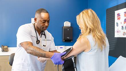 SNHU alum, Anthony Gray '21, who earned an MSN degree, taking a patient's blood pressure.