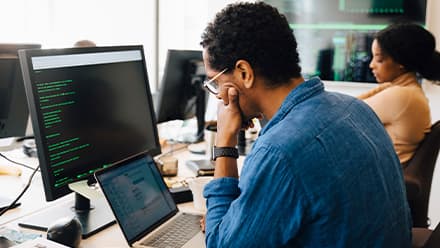 A professional in a cyber security role working on a computer.