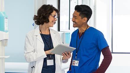 Two healthcare professionals with different types of master’s degrees discussing a chart in a healthcare facility.