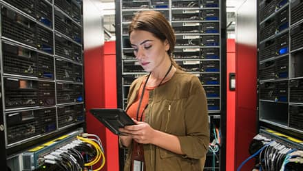 A woman with an associate degree in IT working in a server room.