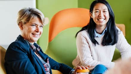 Two professionals learning what MBA stands for as they sit in a business meeting.