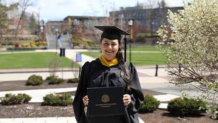 Maisoon Mir dressed in a graduation cap and gown, at SNHU, an institutionally accredited university, celebrating her Master of Science in Information Technology.