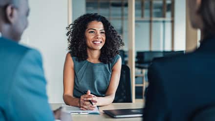 A woman sitting in on a meeting with two other people discussing what an MS degree is