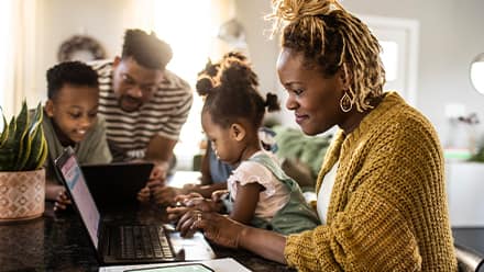 A woman surrounded by family researching what a general studies degree is 