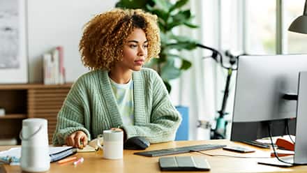 A professional upskilling at her desk, using a computer.