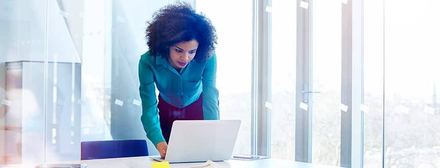 A professional with a business administration degree, standing in front of a laptop.