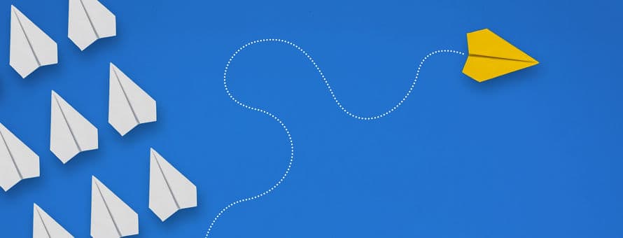 White paper planes and one yellow plane going in a different direction on a blue background