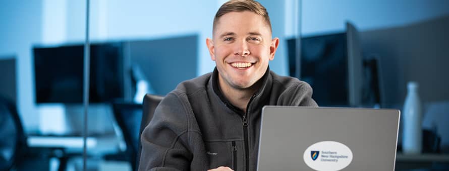 Rob Thomas '24, SNHU graduate with a bachelor's in general studies, studying on his laptop.