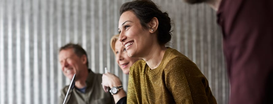 Three IT professionals using active listening and other soft skills at a presentation.