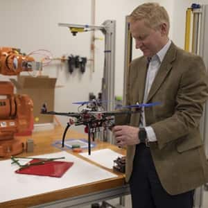 Dr. Kirk Kolenbrander holding a drone inside a CETA engineering lab.