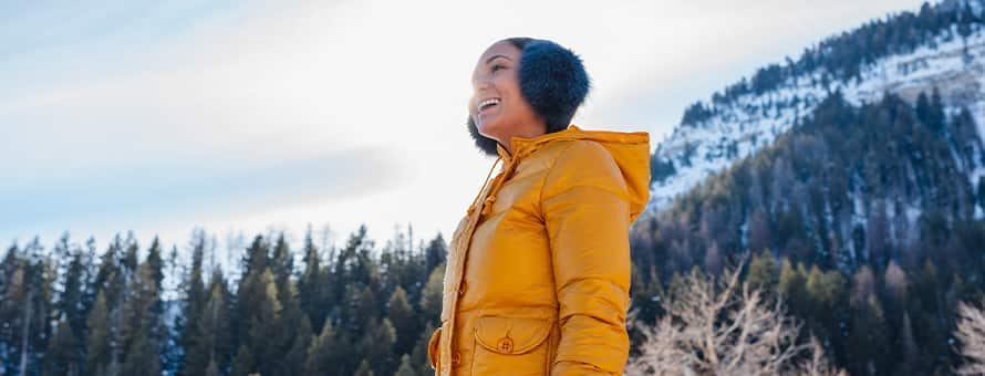 A person hiking during Dry January, wearing a coat and earmuffs.