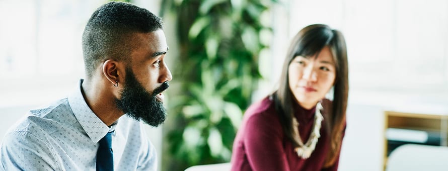 A man and a woman in discussion during a work meeting