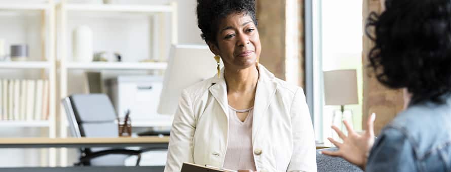A psychiatrist speaking to a patient in their office