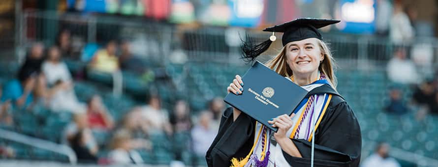 SNHU Graduate holding diploma