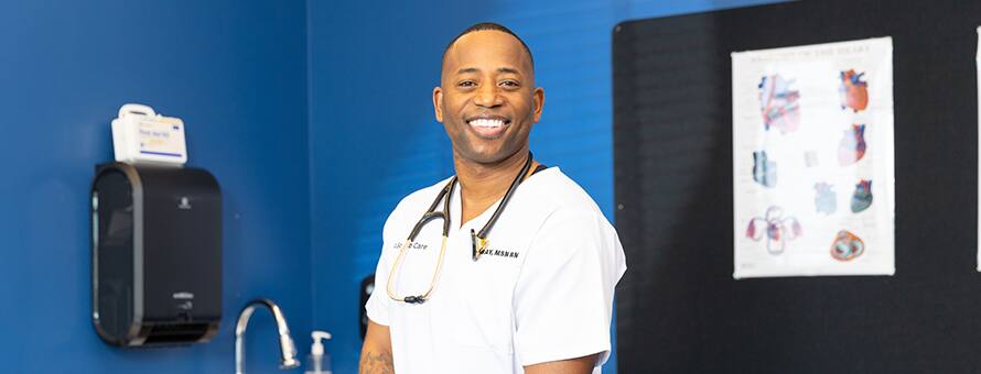 Anthony Gray, an SNHU graduate with a Master of Science in Nursing, dressed in white scrubs with a stethoscope around his neck.