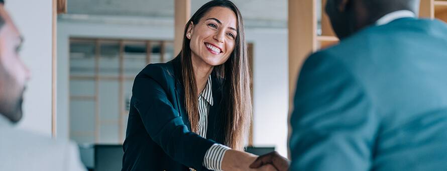 A job candidate shaking hands with two employers after learning how to change careers.