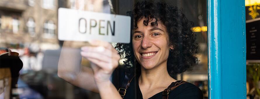 A woman who started her own business flipping the open sign to her new shop
