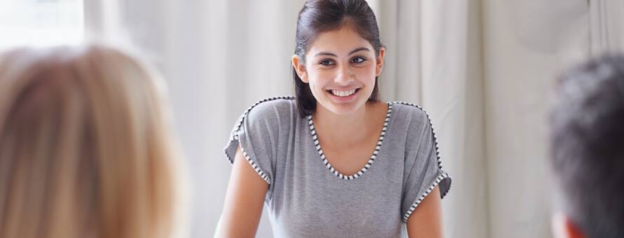 A human resources management student sitting at a table, learning what she can do with an HR degree from two professionals.