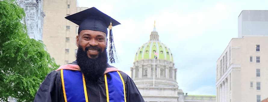 Kemar Reid dressed in his graduation cap and gown.