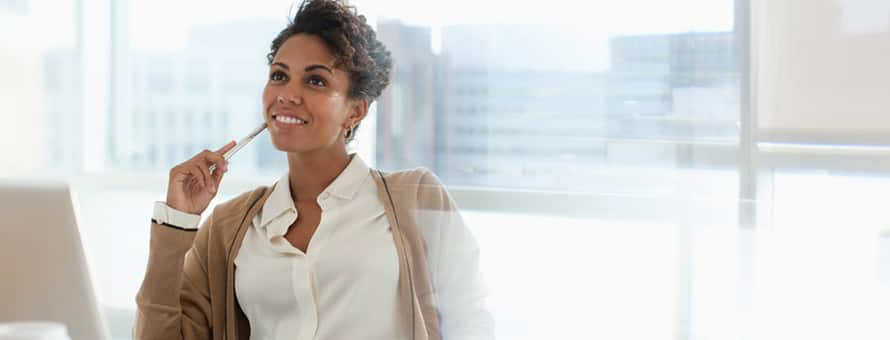 A higher education administration graduate working at a desk.