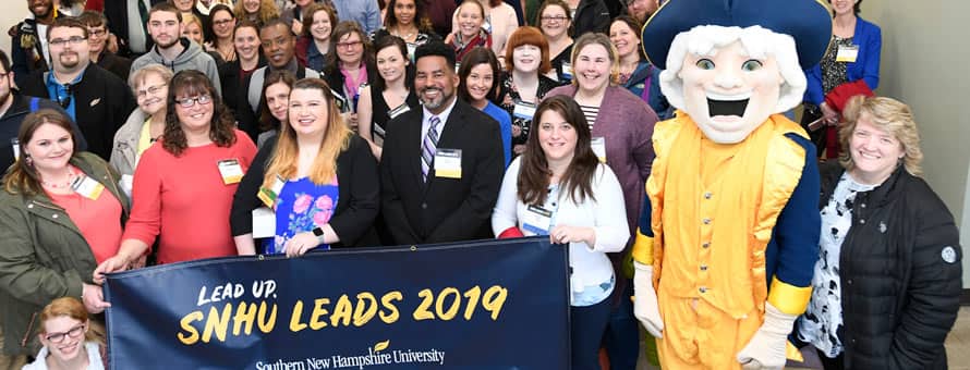 A large group of people at the 5th annual SNHU LEADS Conference and a banner reading Lead Up SNHU LEADS 2019 Southern New Hampshire University.