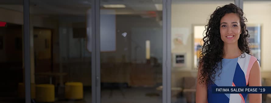 SNHU alumni Fatima Salem Pease standing in front of a conference room, with the text "Fatima Salem Pease '19"